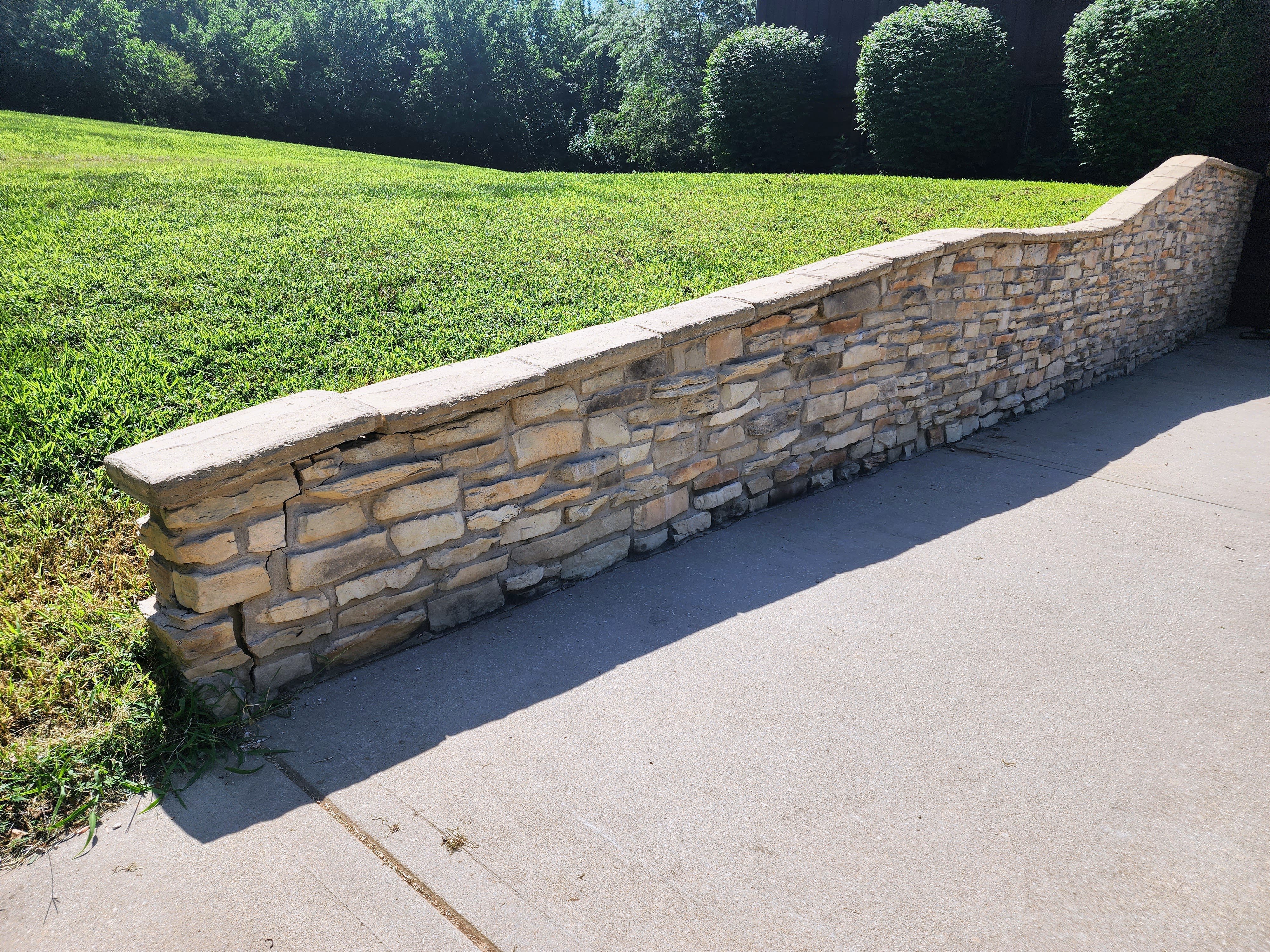 Stone retaining wall in a landscaped yard